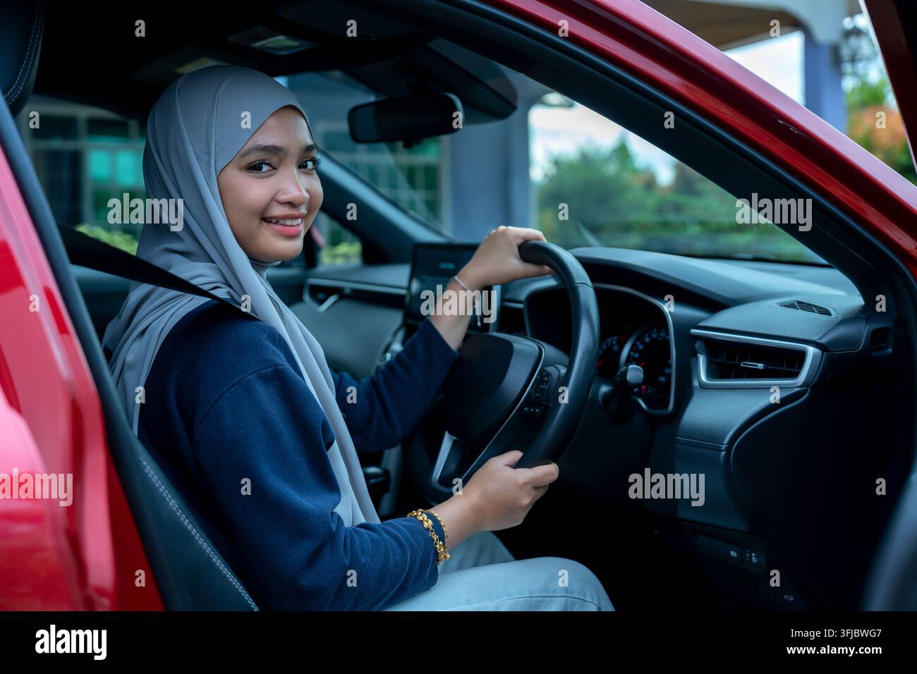 Felice giovane donna in auto Foto Stock