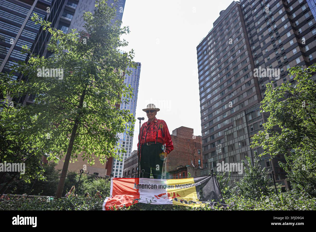 New York, New York, USA. 19 set, 2026. L’anziano delle Prime Nazioni Delaware Tribe of Indians (Lenape)/Shawnee JOHN THOMAS parla durante il Ritorno del Bisonte: Tatanka Owe Akupi all’Abolitionist Place nel centro di Brooklyn, con uno striscione dell’American Indian Movement Grassroots esposto ai suoi piedi. Quarant’otto pupazzi di bisonte a grandezza naturale si sono spostati dall’Abolitionist Place al Brooklyn Bridge Park, accompagnati da anziani Lenape e Lakota e partecipanti delle Prime Nazioni, richiamando il recupero del bisonte dalla quasi estinzione e il suo significato culturale e spirituale per i popoli indigeni. (Credito immagine: Foto Stock