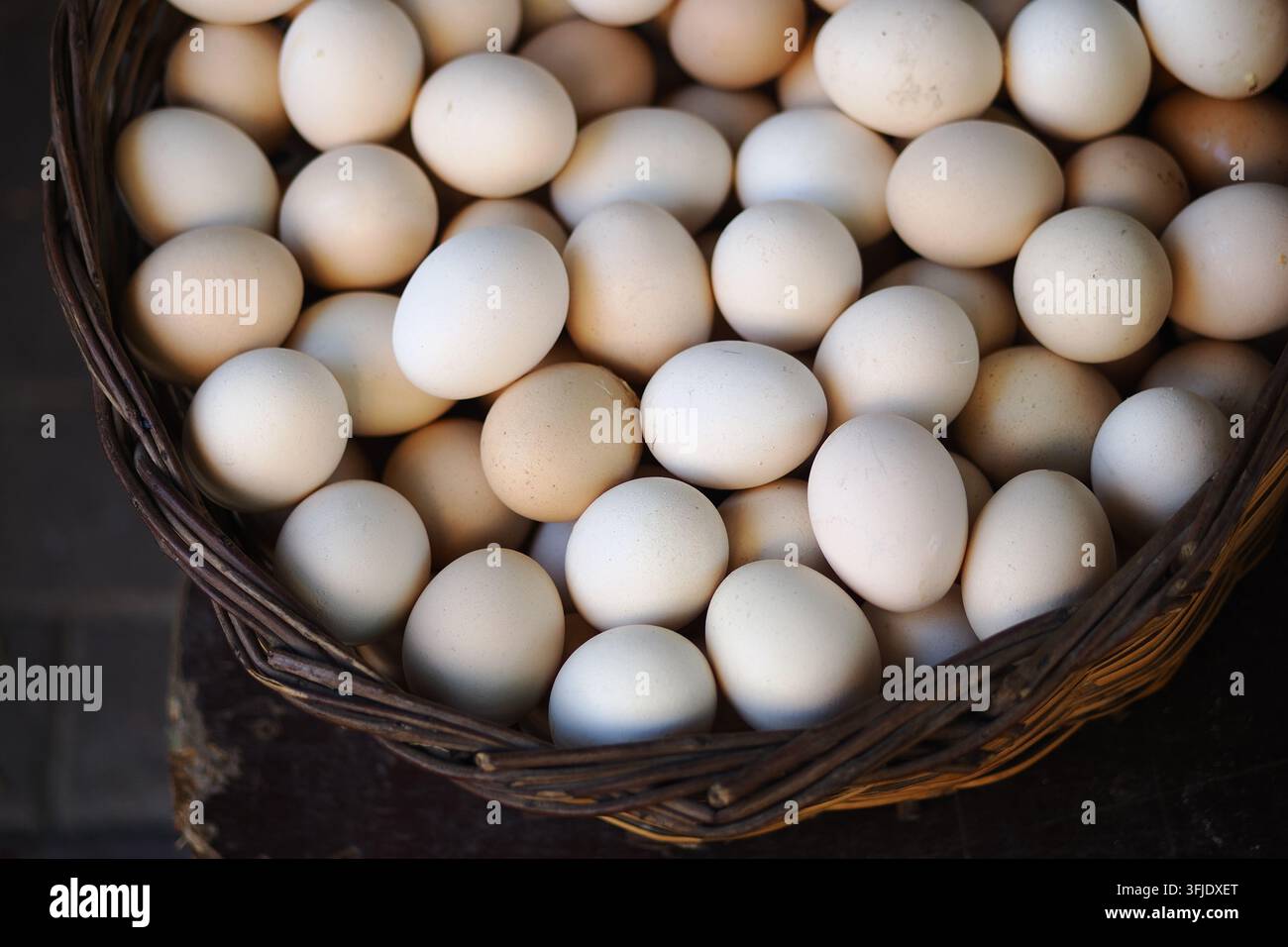 Cesto pieno di uova in un mercato in una giornata soleggiata Foto Stock