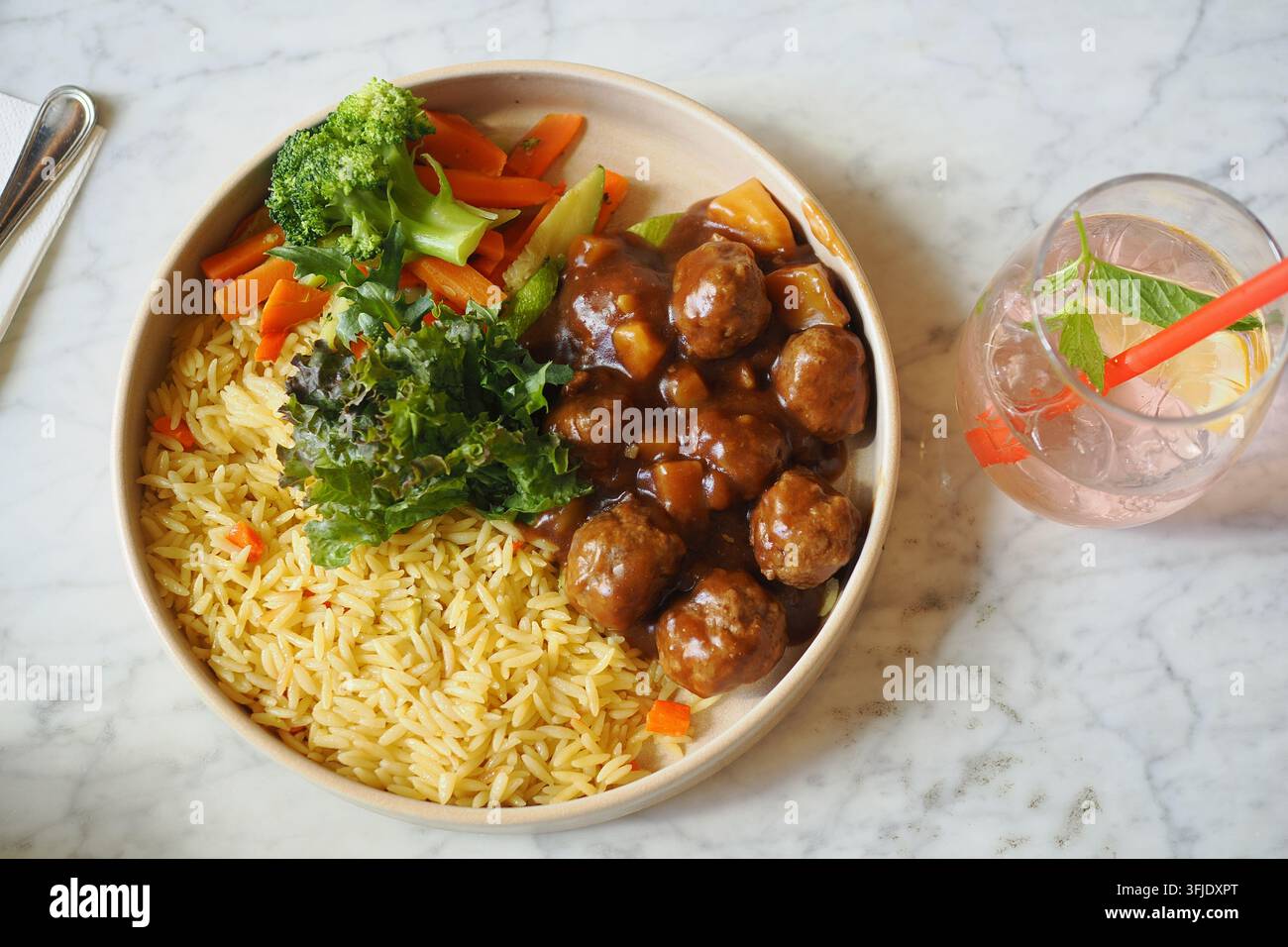 Piatto da cena con riso, verdure e polpette su tavolo di marmo Foto Stock