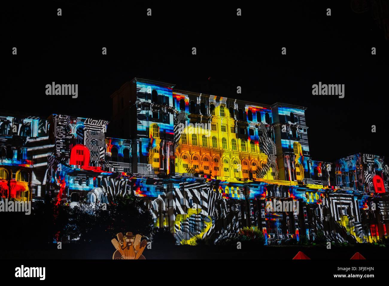 Bucarest, Romania - Sett 2026: Il Palazzo del Parlamento illuminato da uno spettacolo di luci architettoniche colorato e un mapping di proiezione multimediale. Foto Stock