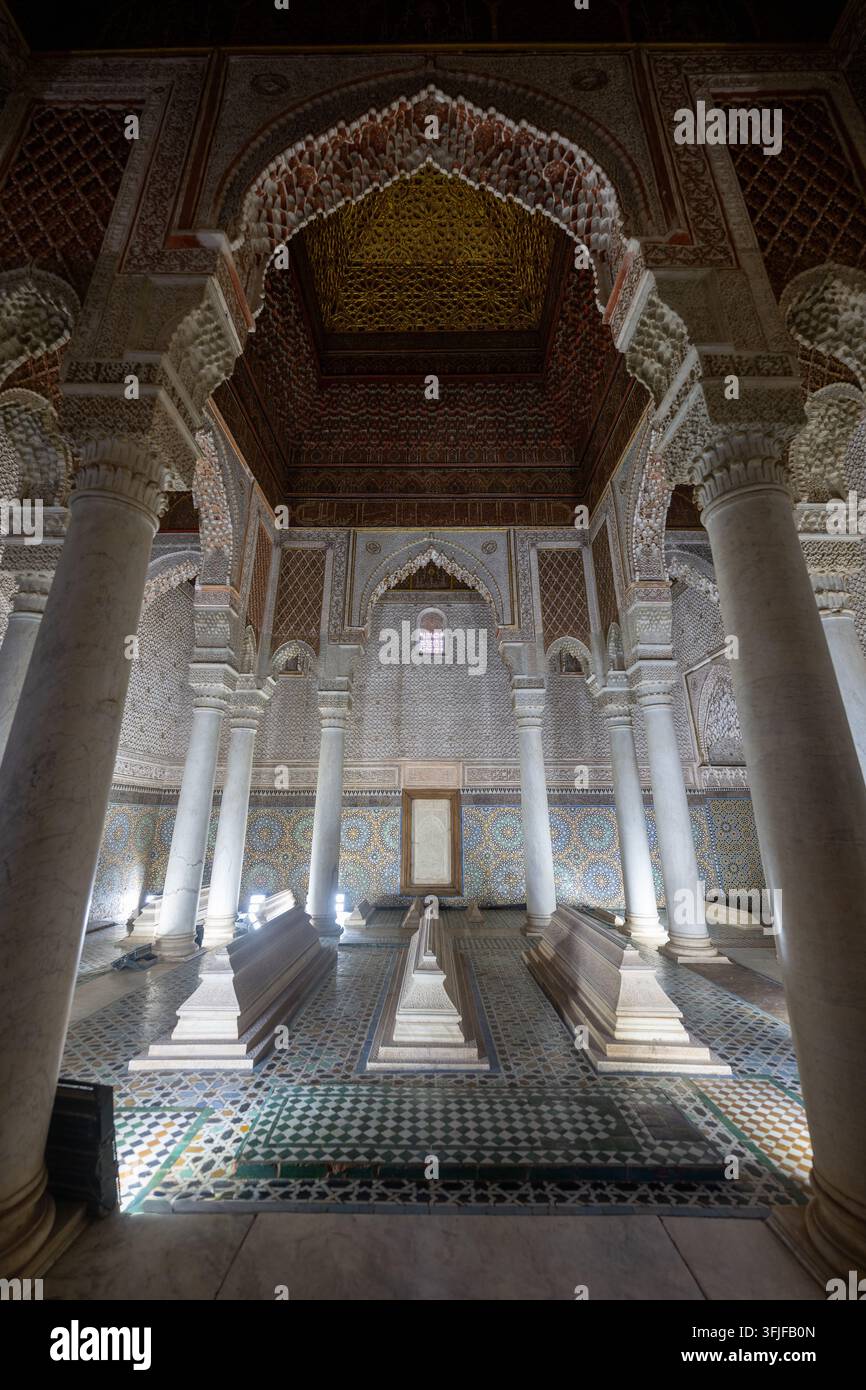 Interno ornato di un mausoleo nelle Tombe Saadiane a Marrakesh, con archi in gesso intagliati, piastrelle a mosaico, colonne di marmo e soffitto in legno decorato Foto Stock