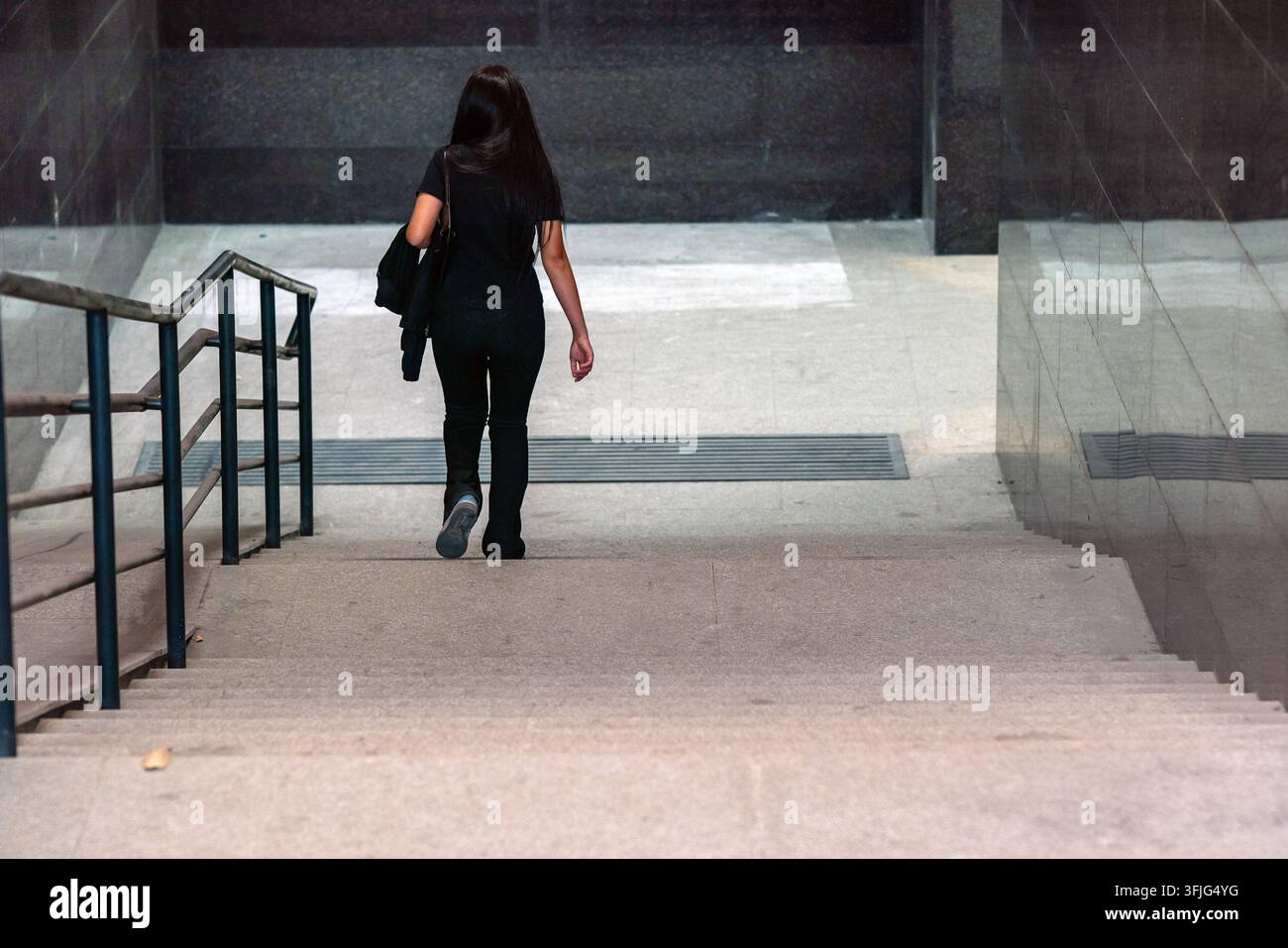 Biscikek, Kirghizistan - 20 settembre 2026 Vista posteriore di una donna che scende le scale verso un passaggio pedonale sotterraneo moderno di recente costruzione Foto Stock