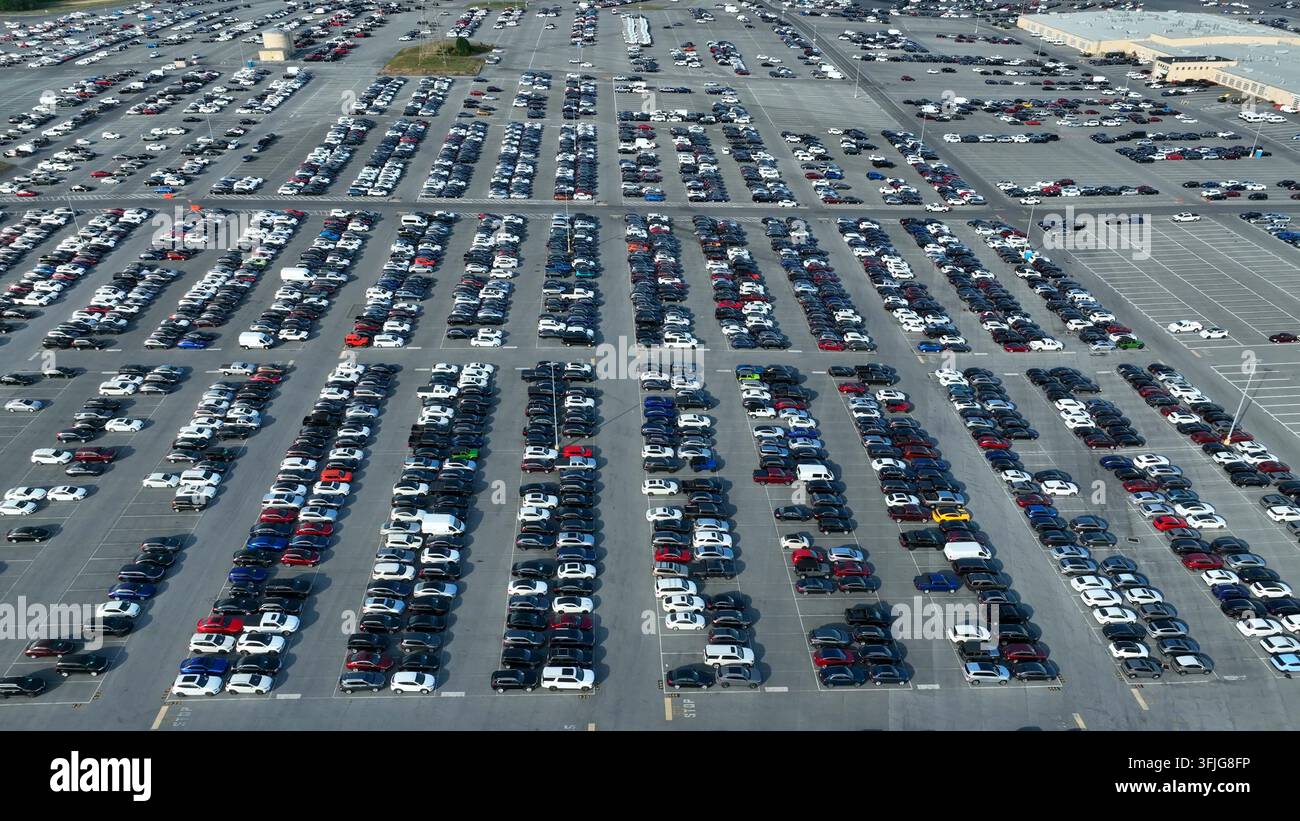 Ripresa aerea alta con ritiro e inclinazione verso l'alto che rivela un ampio parcheggio presso la Manheim Auto Auction. Migliaia di auto nuove e usate per la vendita all'ingrosso ai rivenditori su Foto Stock