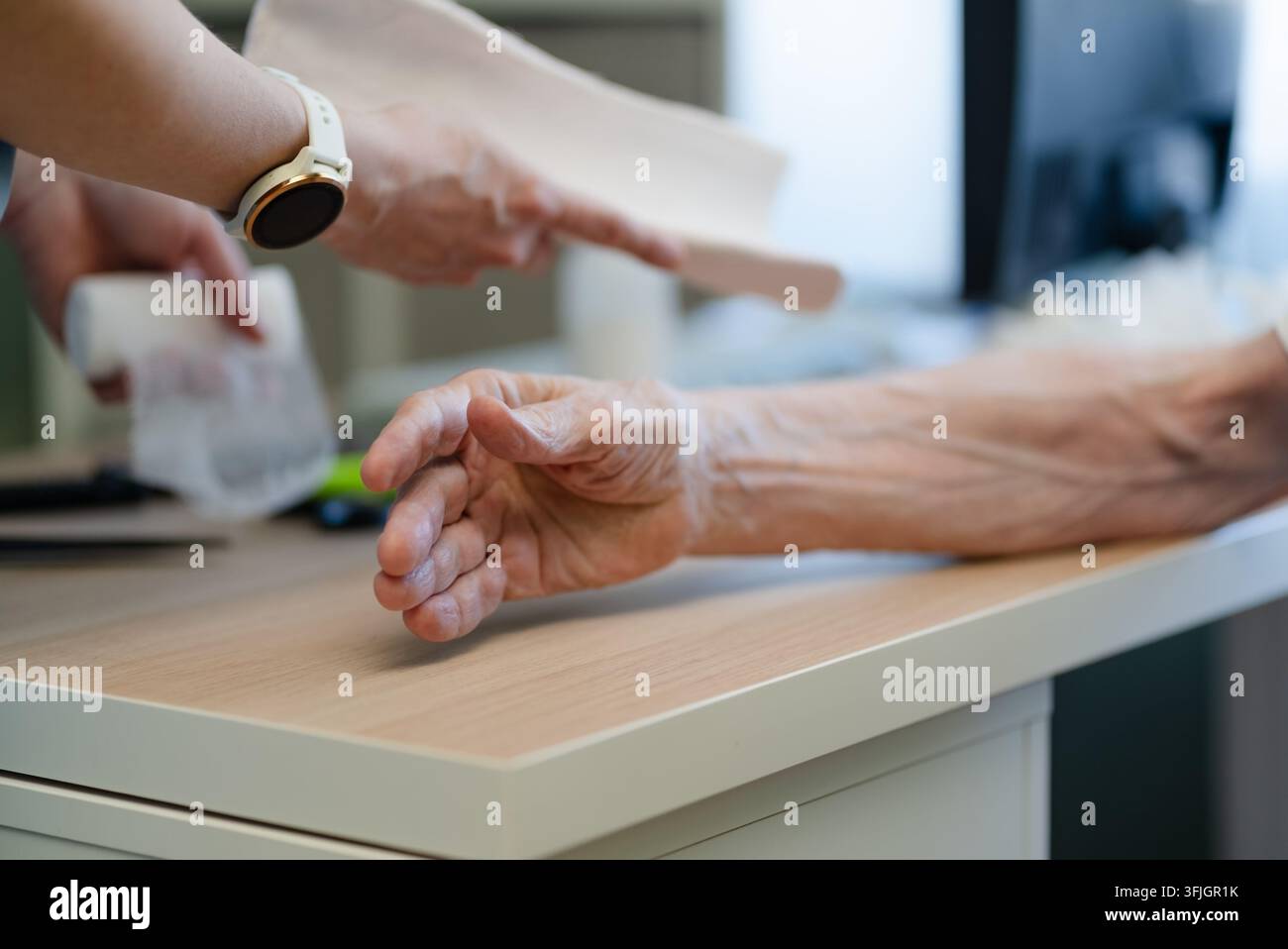 Uomo anziano che riceve assistenza compassionevole per anziani da un'infermiera dedicata in una clinica medica. Pensionato più anziano che viene assistito e supportato da un operatore sanitario premuroso durante una consulenza geriatrica Foto Stock