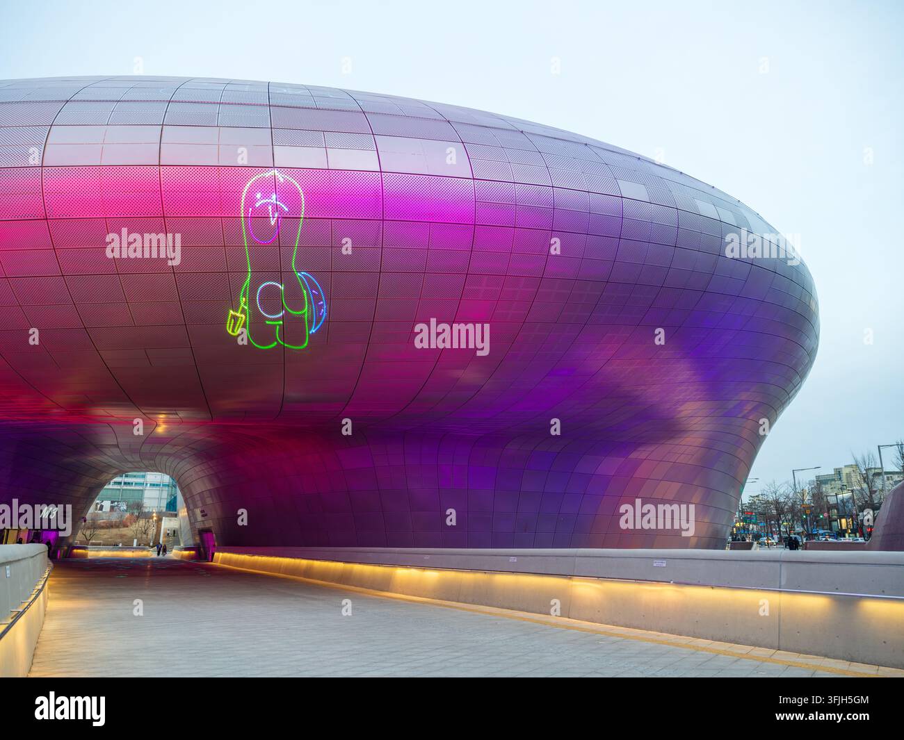 Vista del futuristico Dongdaemun Design Plaza con la sua facciata metallica liscia illuminata da vivaci luci al neon viola e rosa a Seoul, Seoul, Sou Foto Stock