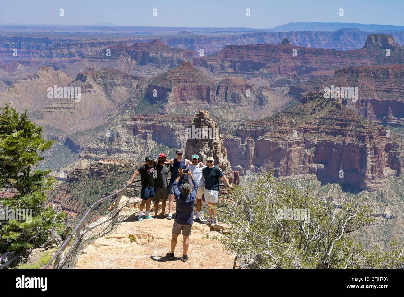 North Rim Grand Canyon, Arizona, USA - 1 luglio 2026: Persona che scatta una foto di un gruppo di amici in posa al punto panoramico di Point Imperial Foto Stock