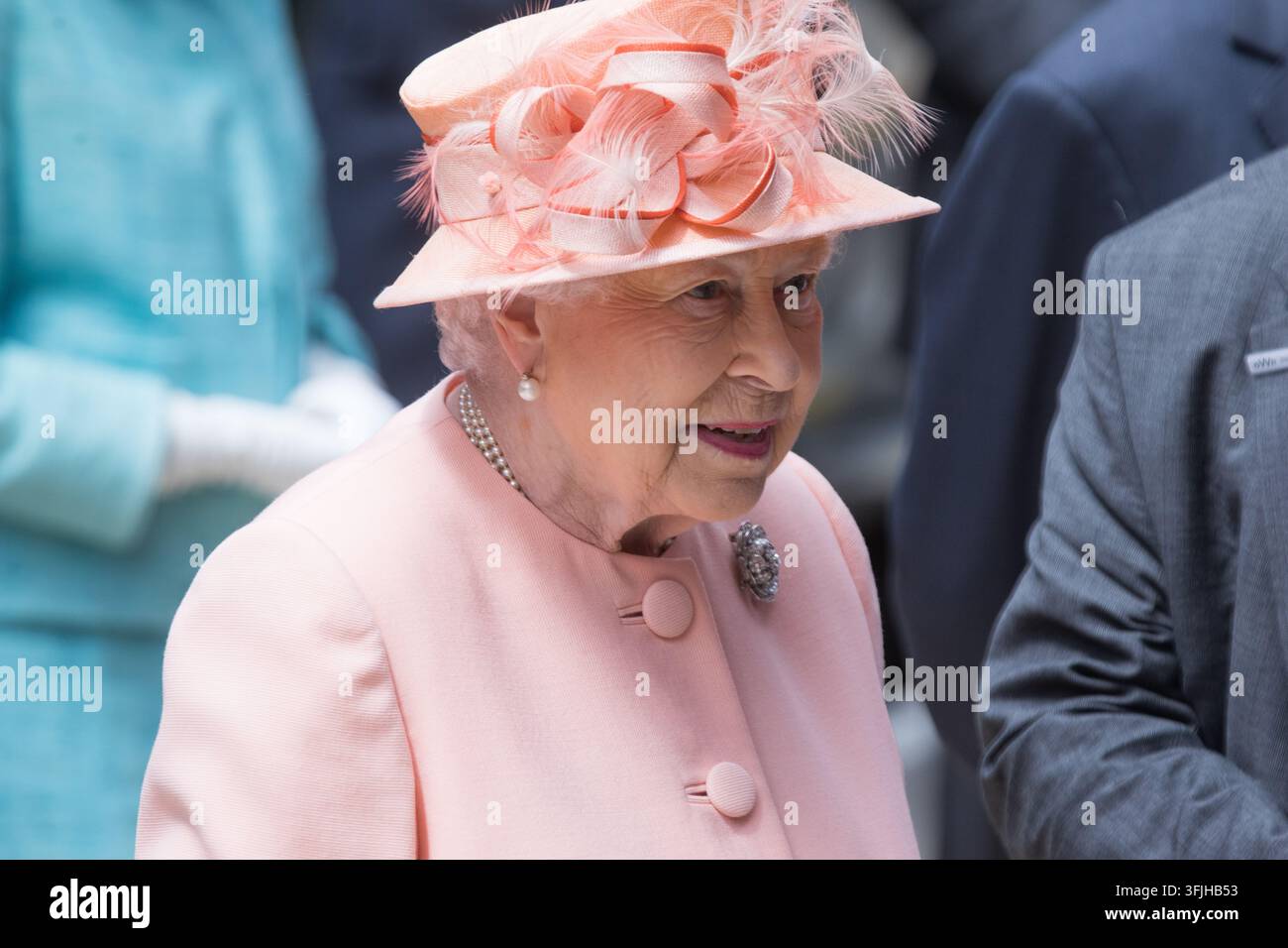 La regina Elisabetta II con un cappello rosa e un cappotto rosa chiaro partecipa a un impegno reale al Buckingham Palace di Londra. Foto Stock