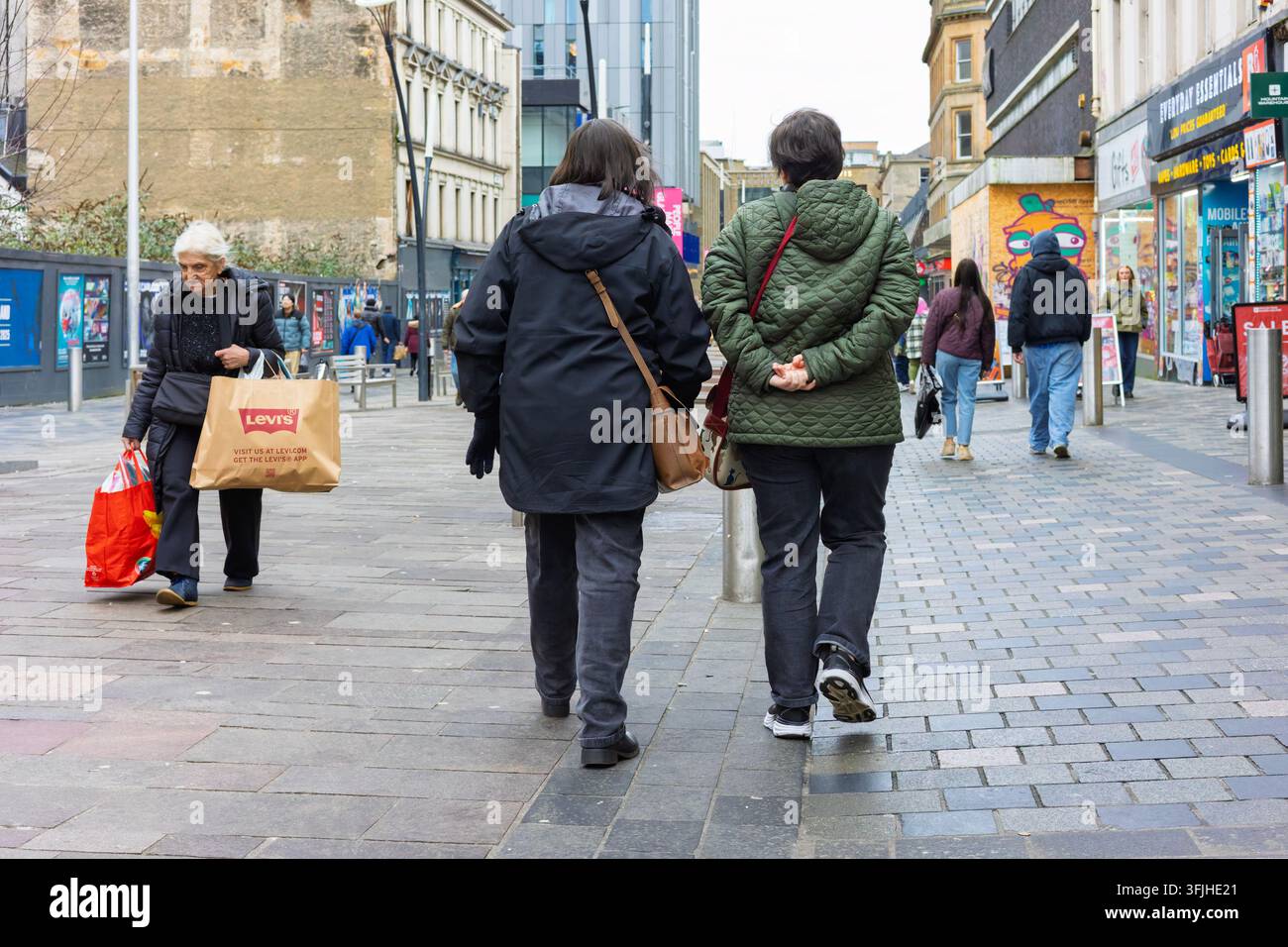 GLASGOW, SCOZIA - 27 DICEMBRE 2025: Acquirenti portano borse, compresa una borsa marchiata Levi's, mentre camminano lungo Sauchiehall Street, Glasgow, dur Foto Stock