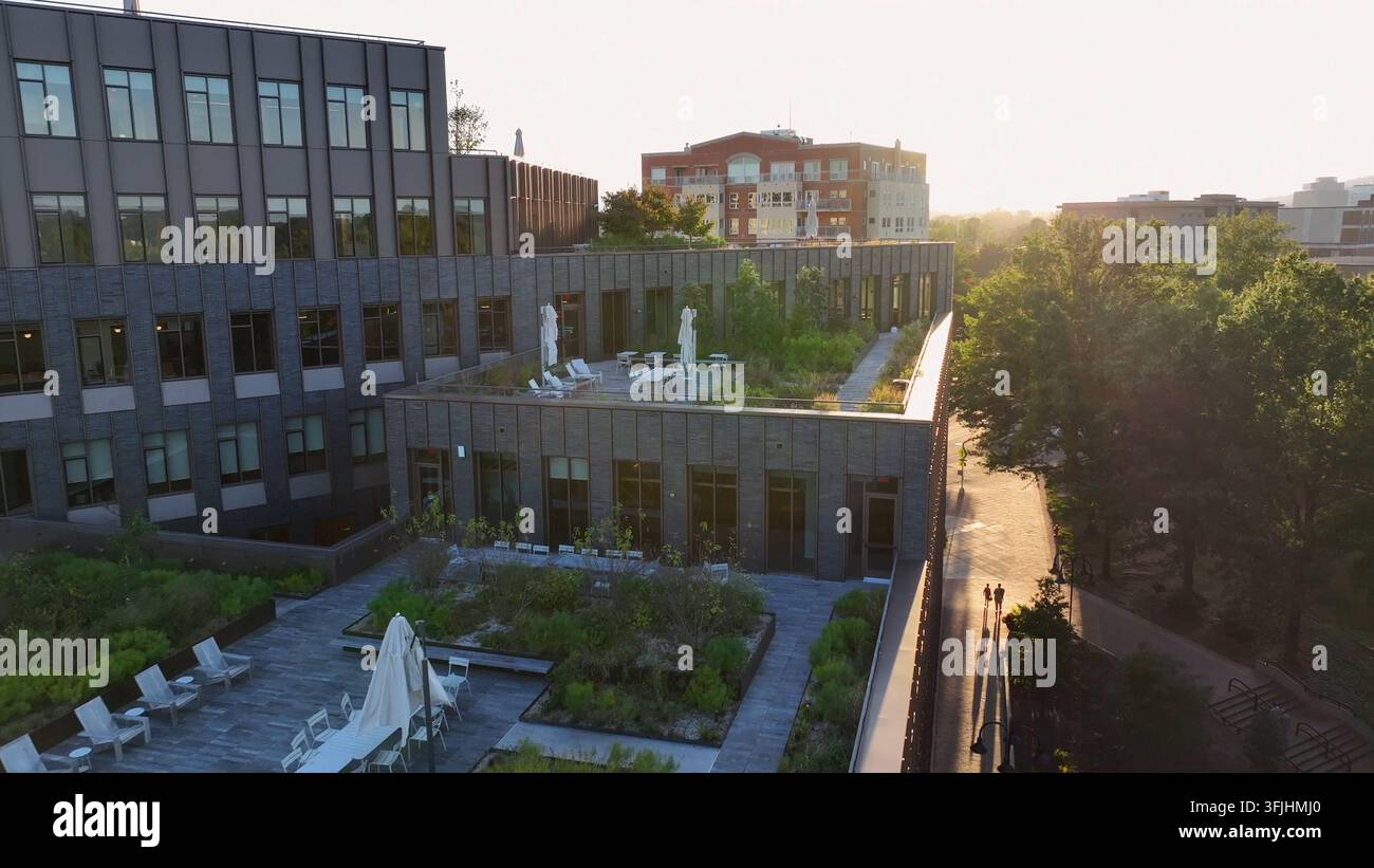 Tetto verde in una città degli Stati Uniti. Moderno, ecologico, vita sostenibile, tema ESG. Volo aereo sopra un grattacielo futuristico al tramonto, Charlottesville, Virg Foto Stock