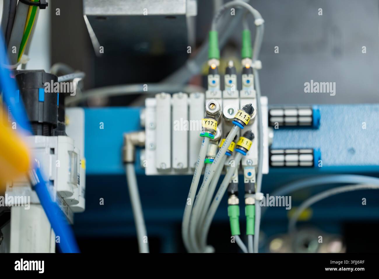 Collettore di valvole pneumatiche con tubi dell'aria collegati, cavi elettrici ed etichette di identificazione, che rappresenta il controllo dell'aria compressa Foto Stock
