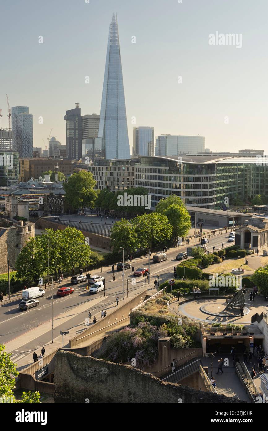 I turisti visitano il castello storico del Tower of London per fare turismo, con il grattacielo The Shard che si erge nel centro di Londra. Foto Stock