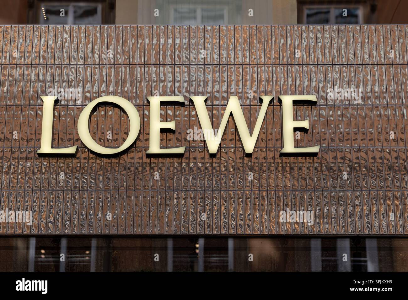 Vienna, Austria, 12 settembre 2026, Il logo Loewe appare su una facciata di negozio in piastrelle marroni strutturate. Foto Stock