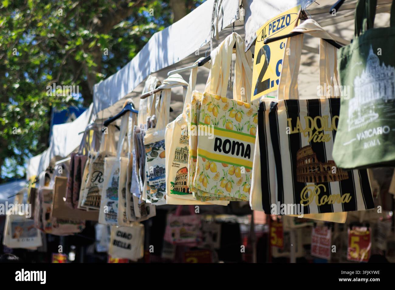 File di borse in tela souvenir appese a uno stand di mercato all'aperto a Roma, Italia. Foto Stock