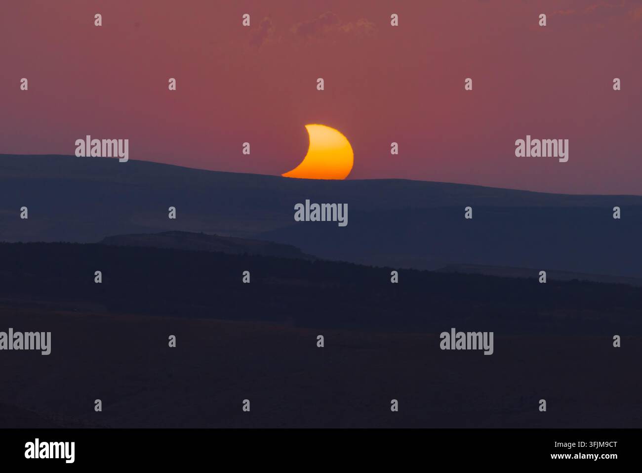 Mentre il sole tramonta in Spagna nel 2026, un'eclissi parziale crea una silhouette mozzafiato, tingendo il cielo di tonalità crepuscolari. Foto Stock