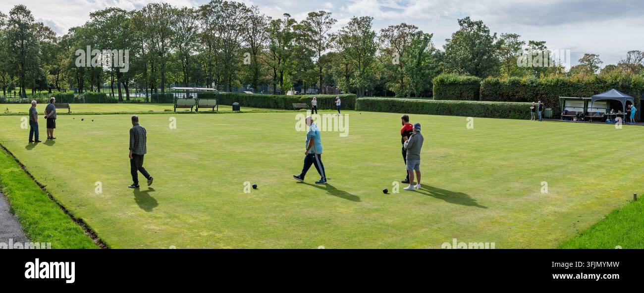 Un gruppo di uomini che giocano a crown green bowls su un prato verde e rigoglioso. Foto Stock