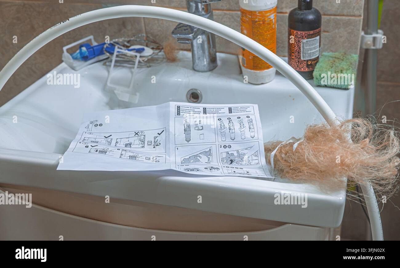 Installazione della caldaia del bagno con materiale di tenuta a tubo in fibra di canapa, tubo di plastica e istruzioni di installazione sul Foto Stock