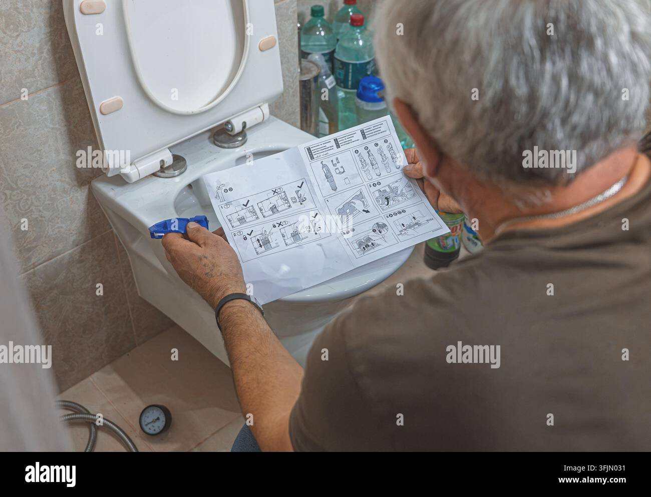 Installazione di un meccanismo di scarico della cisterna del water da parte di un idraulico professionista Foto Stock