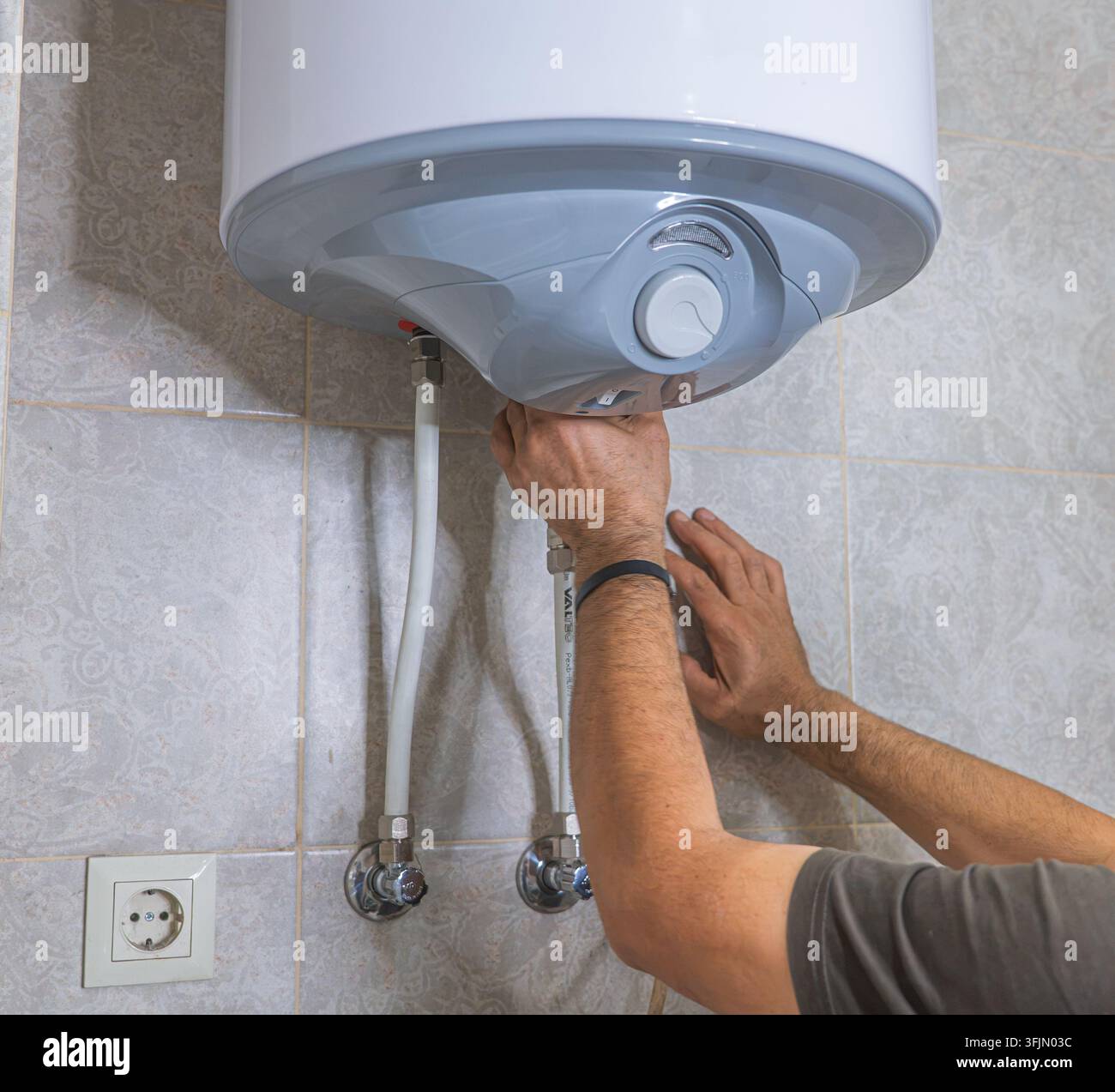 Installazione di una valvola di risciacquo interna e del meccanismo all'interno di un serbatoio di toilette nascosto Foto Stock
