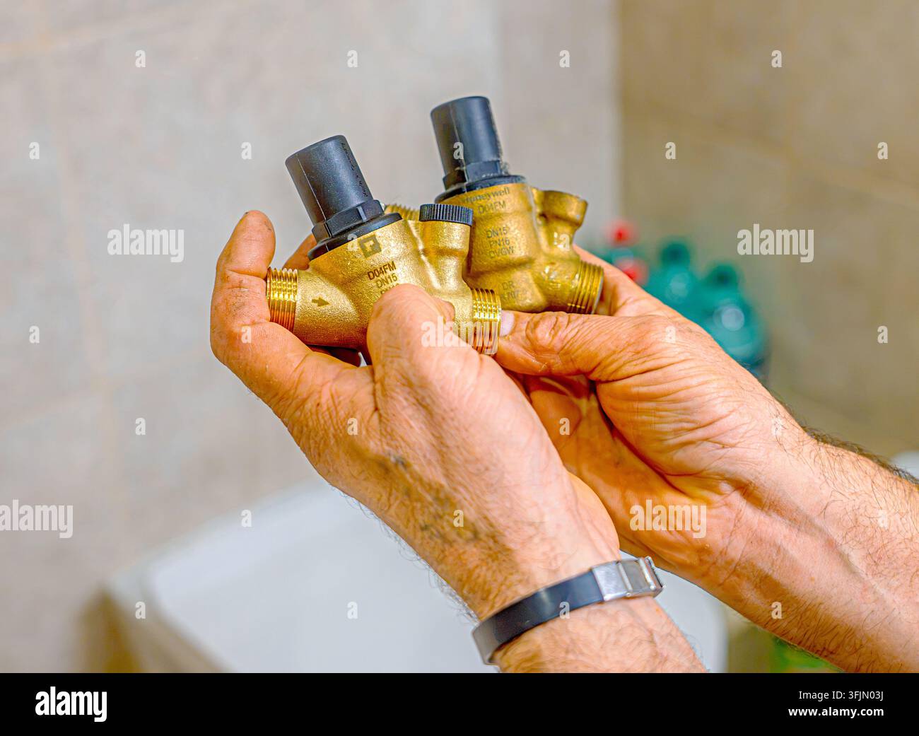Installazione di un regolatore di pressione originale su una caldaia domestica da parte di un idraulico professionista Foto Stock