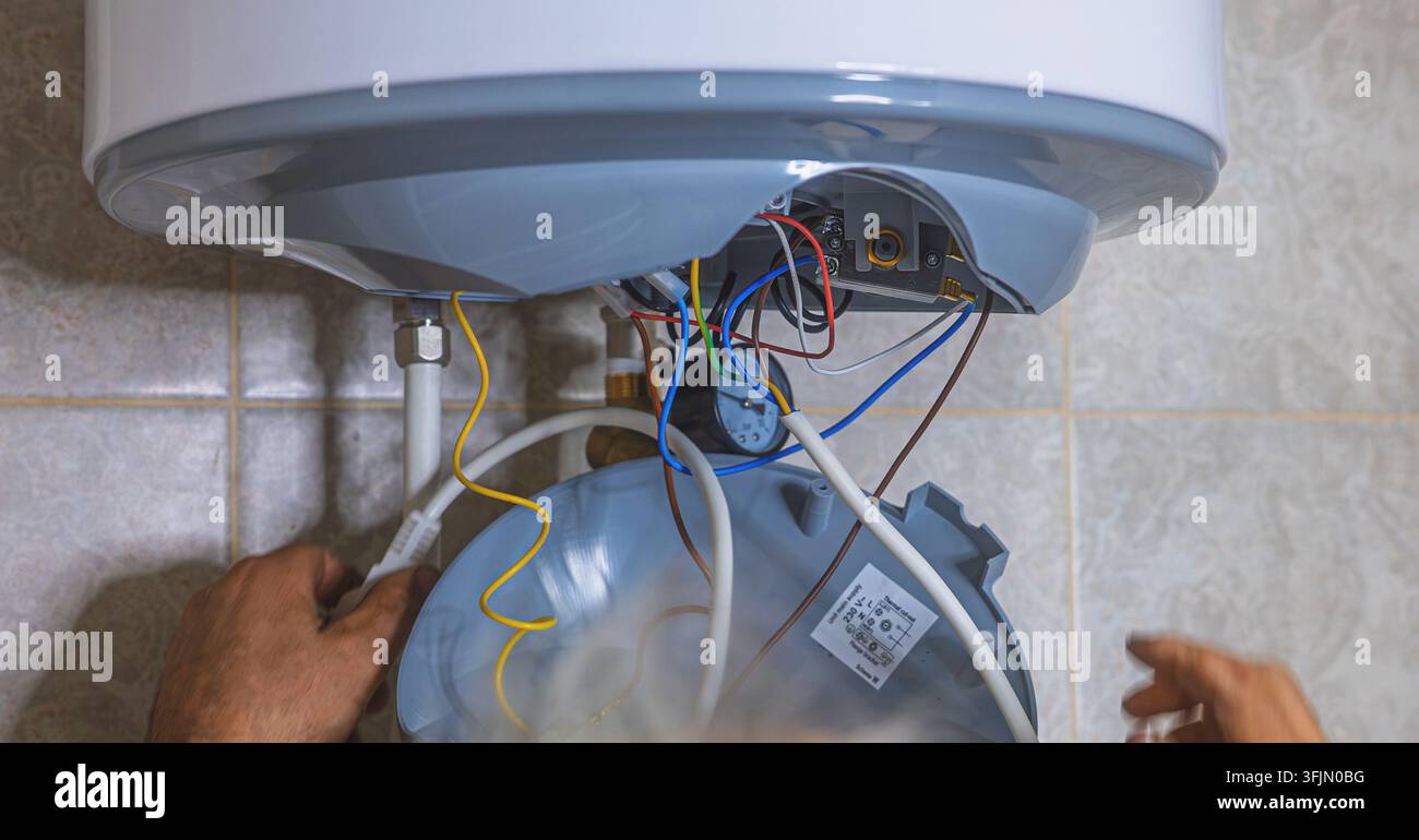Idraulico che installa il meccanismo di scarico interno di una cassetta WC incorporata durante lavori di idraulica.jpg - 3FJ Foto Stock
