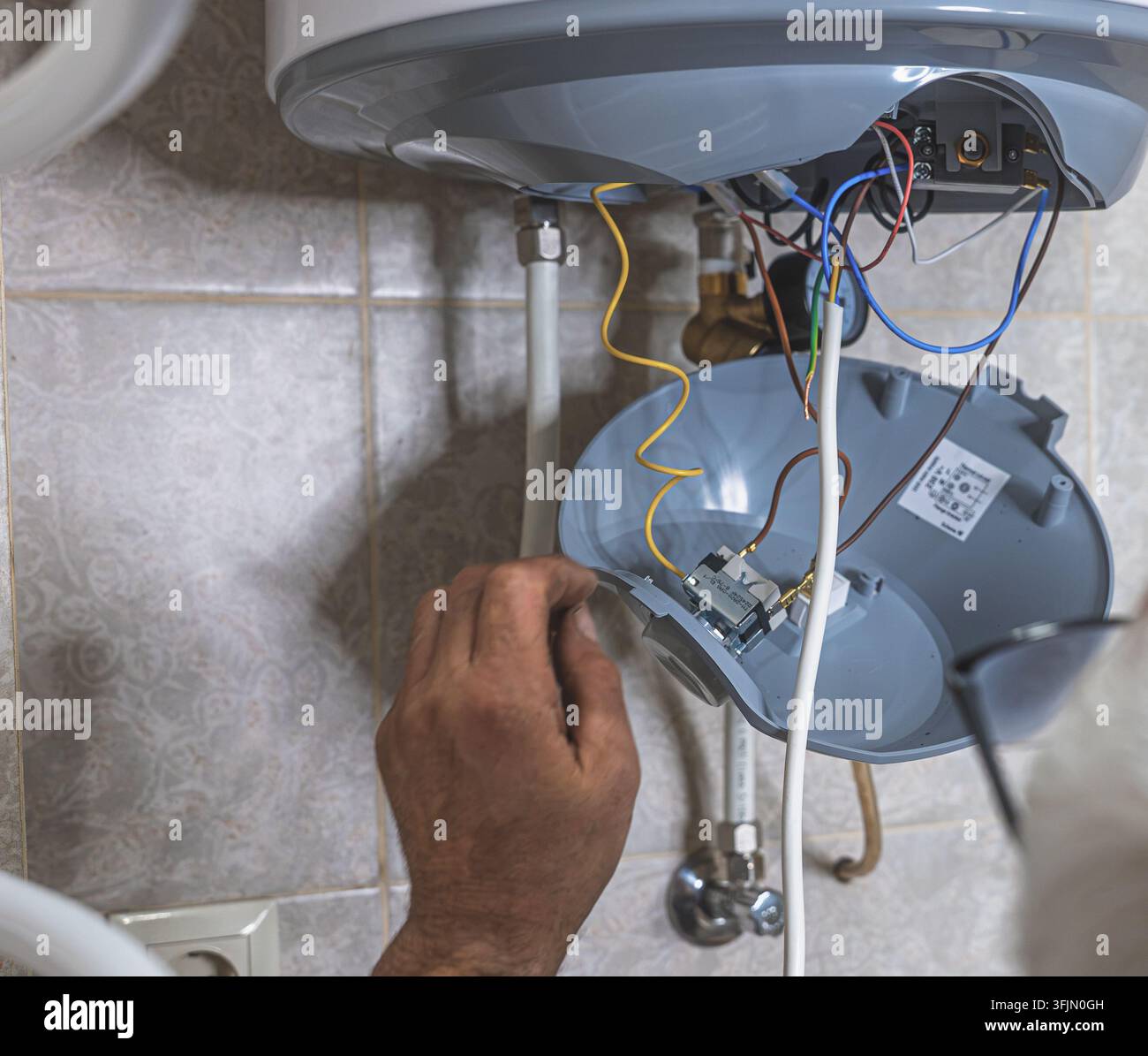 Installazione professionale di un sistema di scarico per serbatoio nascosto da parte di un idraulico esperto Foto Stock