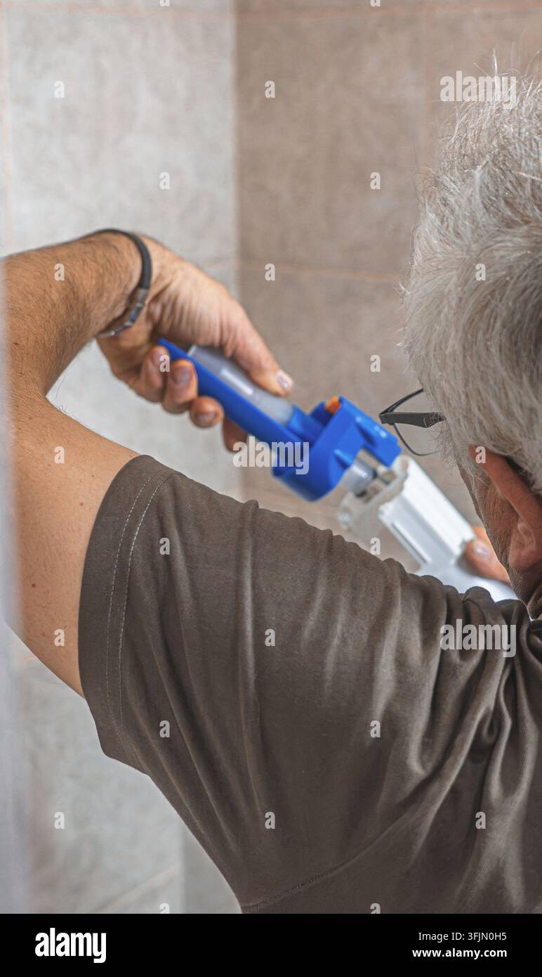 Installazione professionale di un meccanismo di scarico interno per toilette da parte di un idraulico Foto Stock