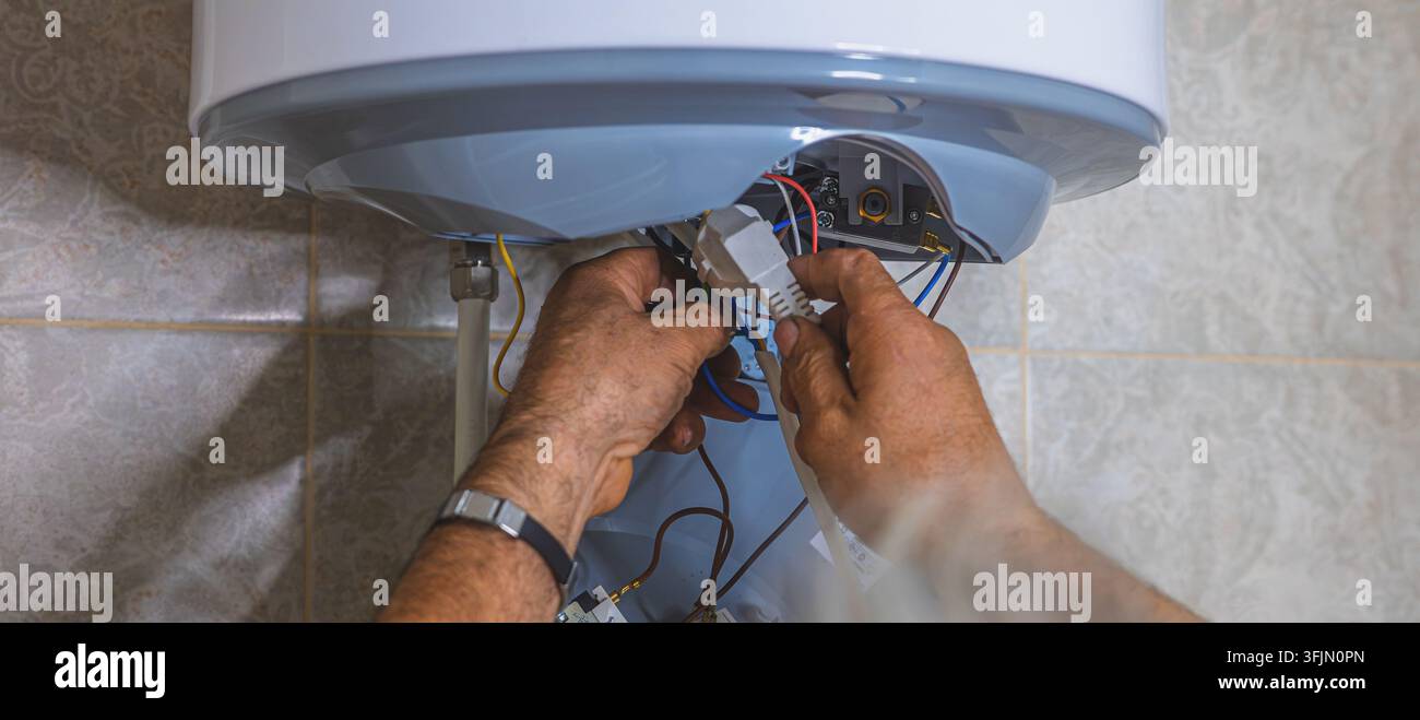 Idraulico professionista che installa un meccanismo di scarico interno in una cisterna di WC nascosta Foto Stock