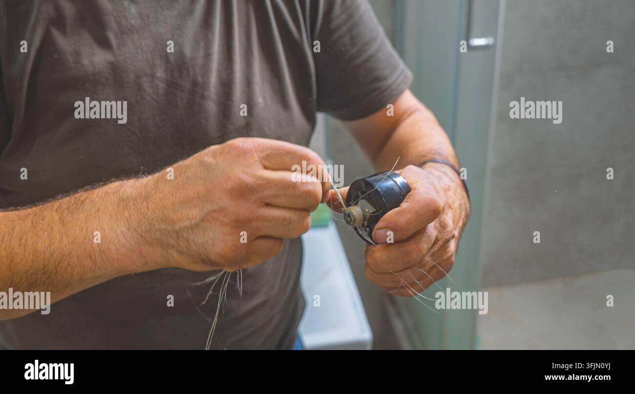 Idraulico professionista che prepara un manometro con fibra di canapa per l'installazione Foto Stock