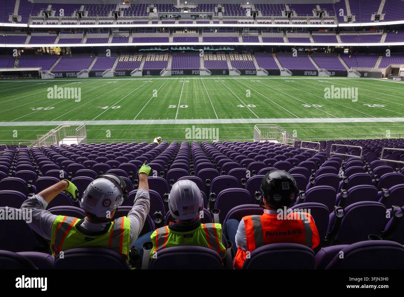 Da sinistra, Pat Ryan, Edward Keegan e Bryan Schabel, con caschi protettivi e giubbotti di sicurezza ad alta visibilità, seduti nei posti a sedere del livello 100 sulla linea delle 50 yard all'interno dello stadio Ryan Field quasi completato della Northwestern University a Evanston, Ill., il 14 settembre 2026. I tre uomini, incluso un rappresentante dello studio di architettura Perkins&Will, hanno ispezionato lo stadio coperto ricostruito, che presenta sedili viola in tutto e un campo di gioco in erba artificiale completamente rivestito con il marchio Ryan Field e Northwestern Wildcats. (Foto di Stacey Wescott/Chicago Tribune/TNS/Sipa USA) Foto Stock