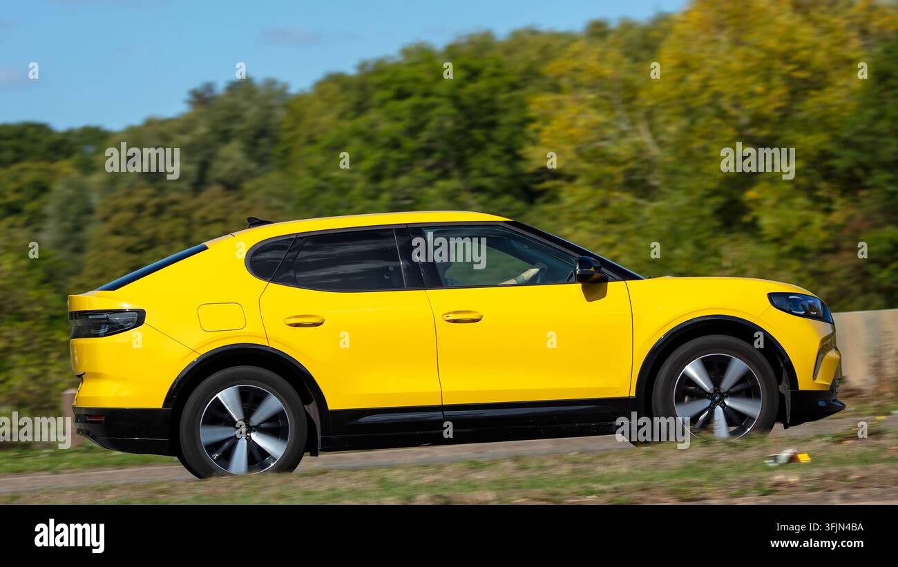 Milton Keynes; Regno Unito - 20 settembre 2026: Auto elettrica Ford Capri gialla del 2024 in corsa su una strada britannica Foto Stock
