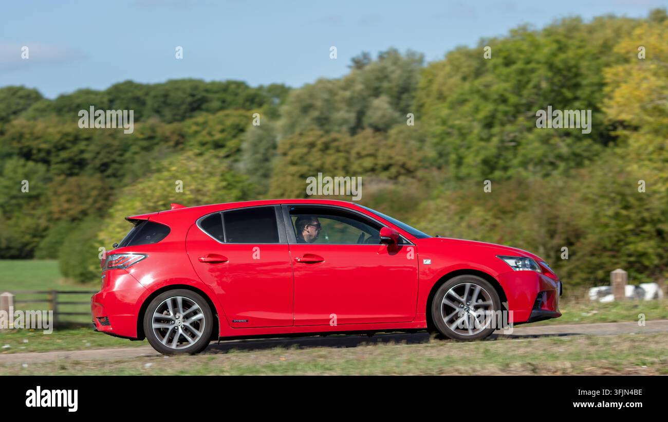 Milton Keynes; Regno Unito - 20 settembre 2026: Auto ibrida elettrica Lexus ct rossa del 2016 in corsa su una strada britannica Foto Stock