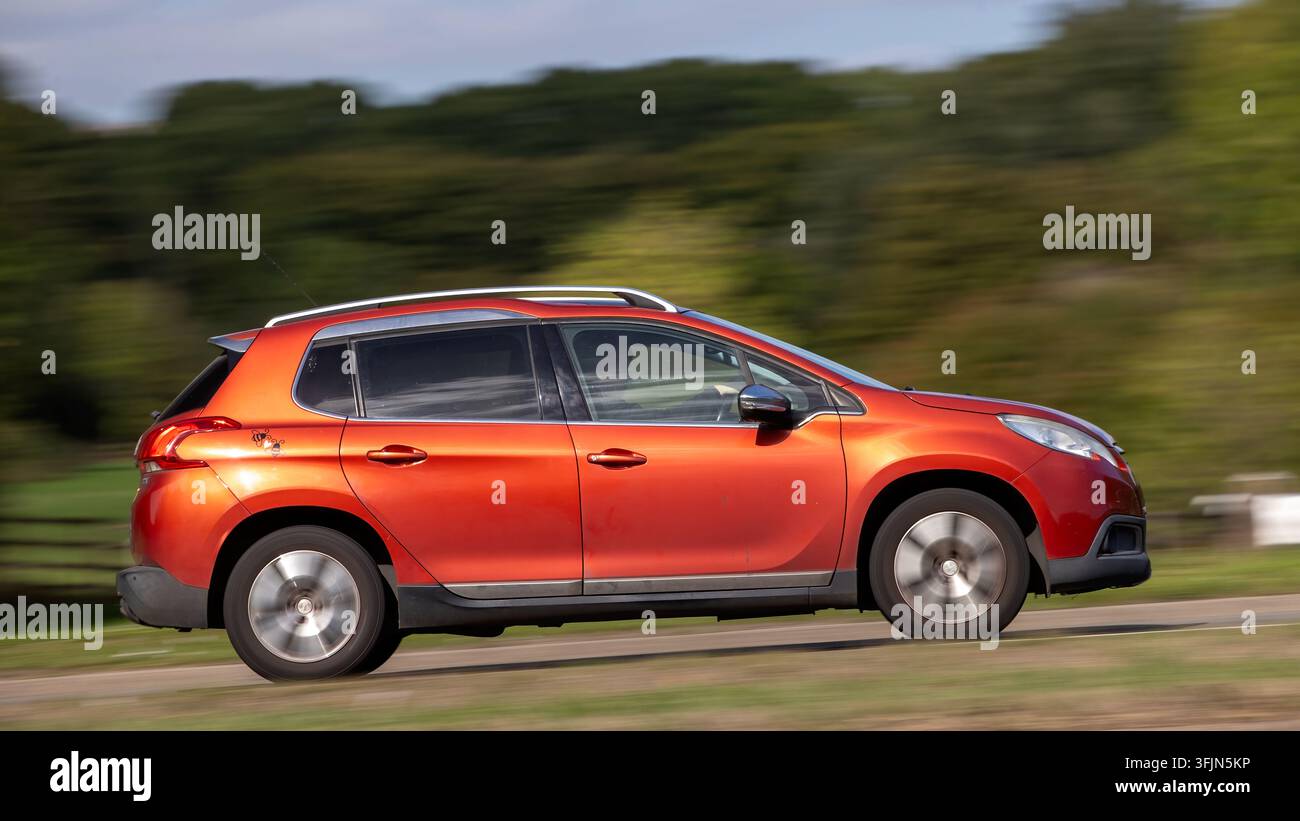 Milton Keynes; Regno Unito - 20 settembre 2026: auto Peugeot 2008 rossa del 2015 in corsa su una strada britannica Foto Stock