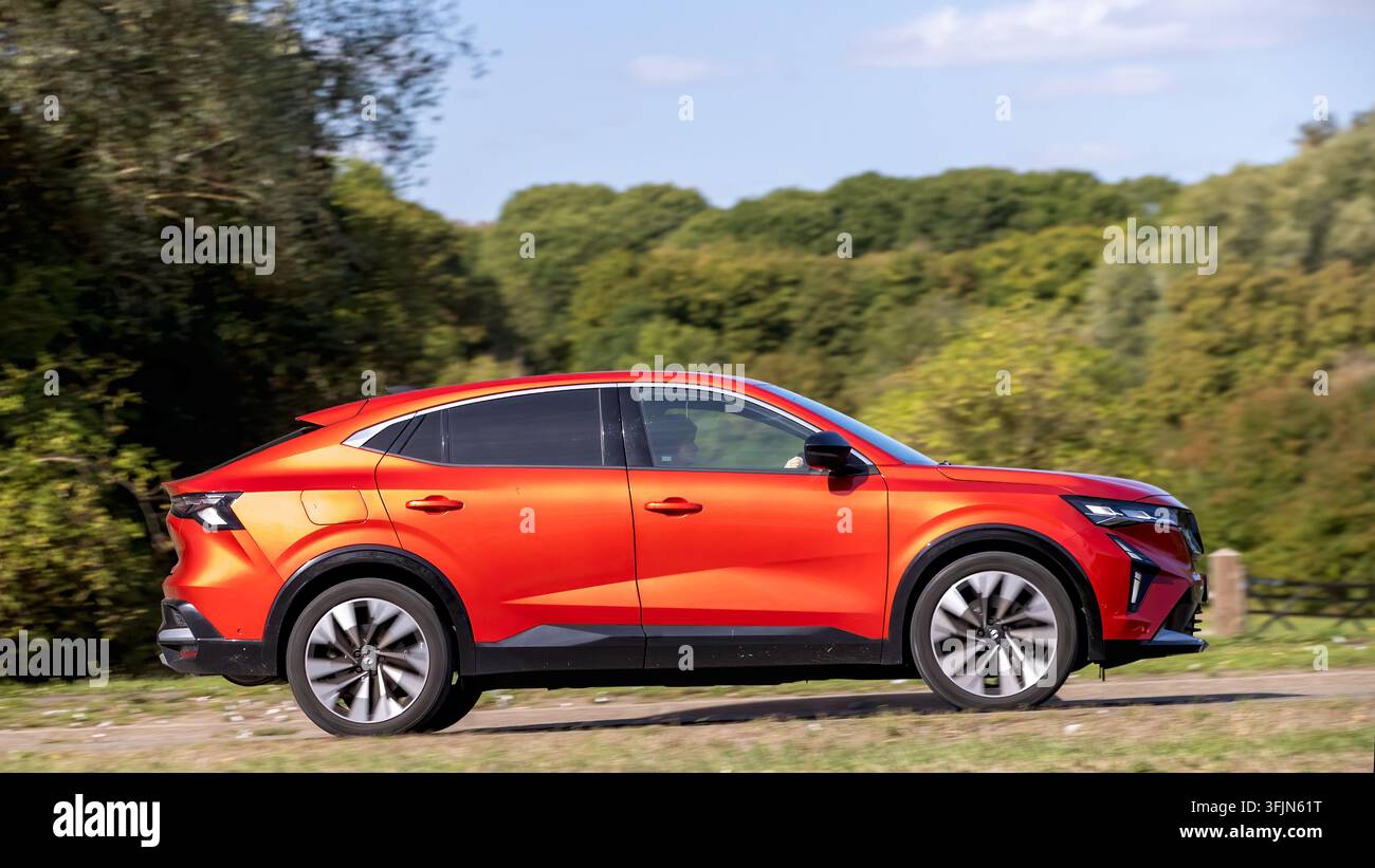 Milton Keynes; Regno Unito - 20 settembre 2026: Auto ibrida elettrica Renault Rafale Techno rossa del 2025 in corsa su una strada britannica Foto Stock