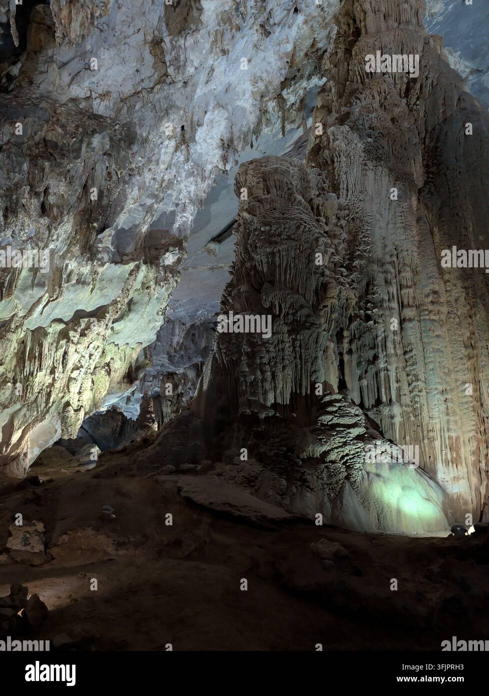 Imponente formazione di stalagmiti e colonne di calcite all'interno di una grotta sotterranea illuminata da luci artificiali. Foto Stock