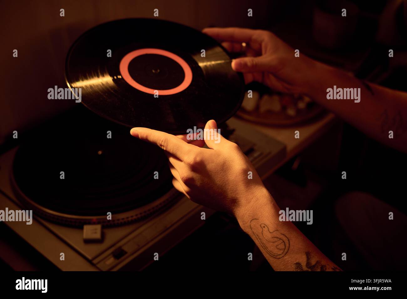 Mani di un uomo che posa un vinile su un giradischi a casa Foto Stock