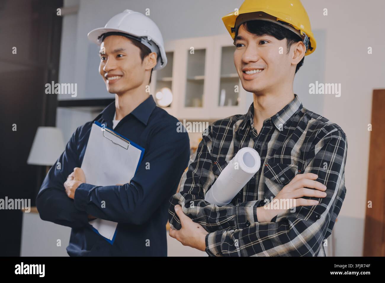 Squadra asiatica di architetti e ingegneri che controlla un modello architettonico di casa usando un metro a nastro sul tavolo nello studio dell'ufficio. Foto Stock