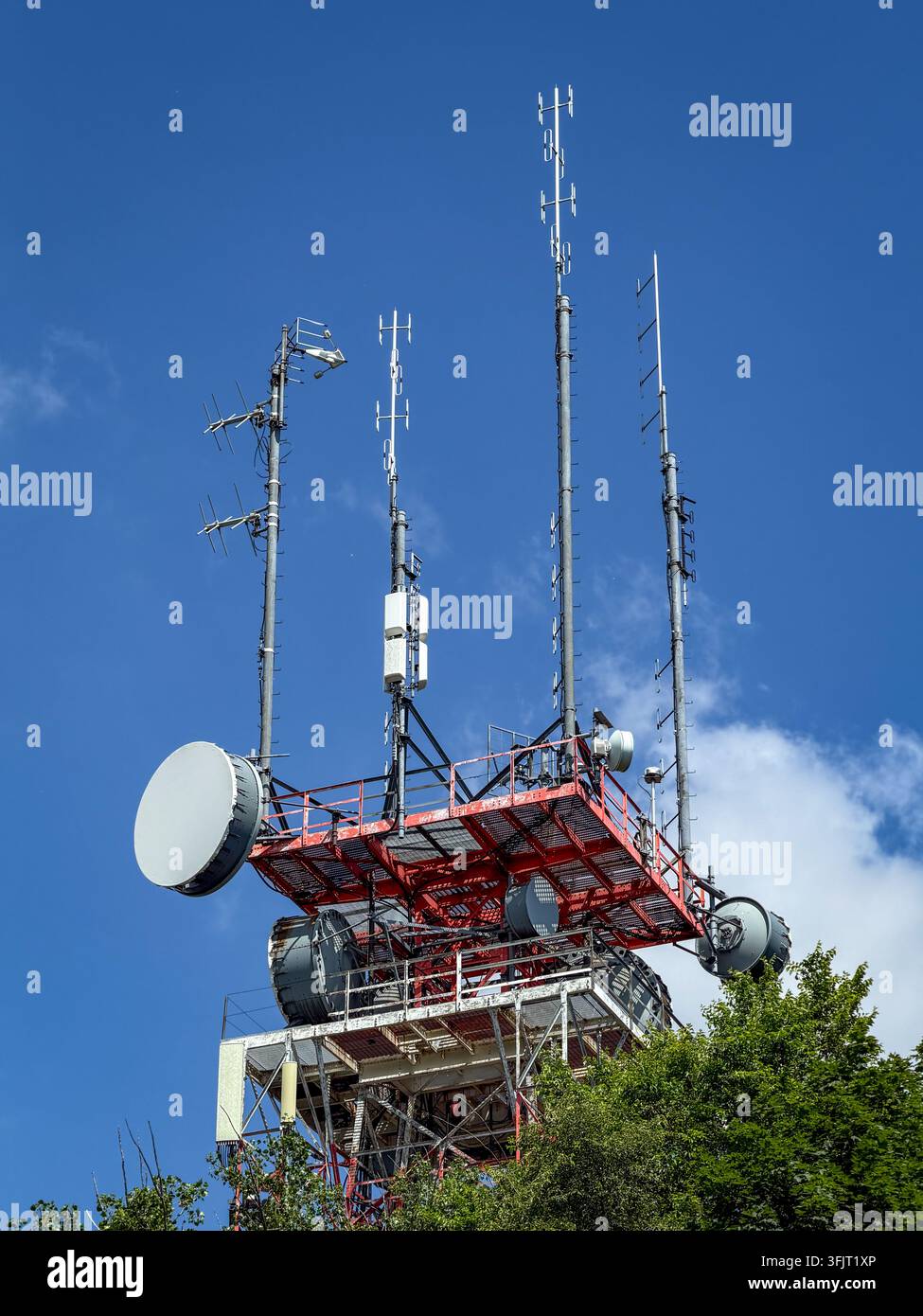 Torre di telecomunicazioni e radiodiffusione con più array di antenne e parabole contro un cielo blu terso nel Parco Monte Reale, Montréal. Foto Stock