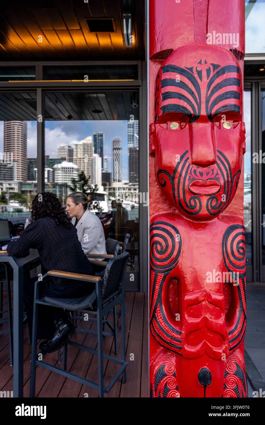 Una scultura in legno maori davanti a un ristorante nel quartiere di Wynyard, Auckland, Nuova Zelanda. Foto Stock