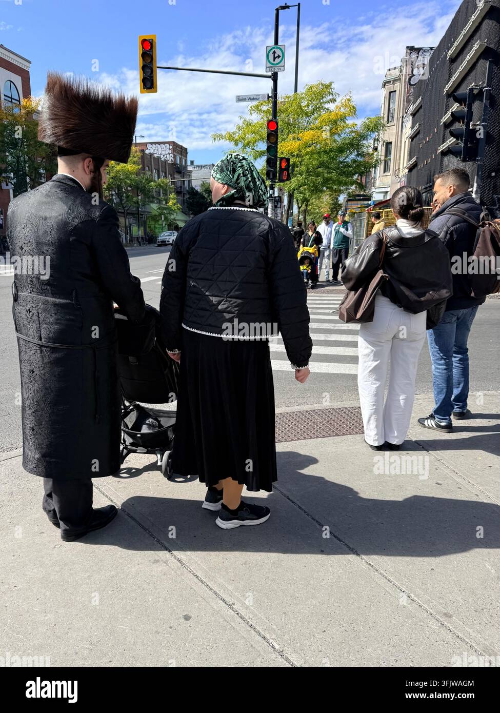 Pedoni che indossano abiti associati alla comunità ebraica chassidica di Montréal a un passaggio pedonale su Park Avenue nel quartiere Mile End, Montréal Foto Stock