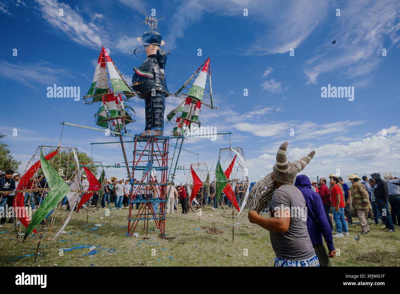Le persone si radunano intorno a un effigie gigante decorata con bandiere messicane durante la celebrazione della Quema de Panzones. Foto Stock