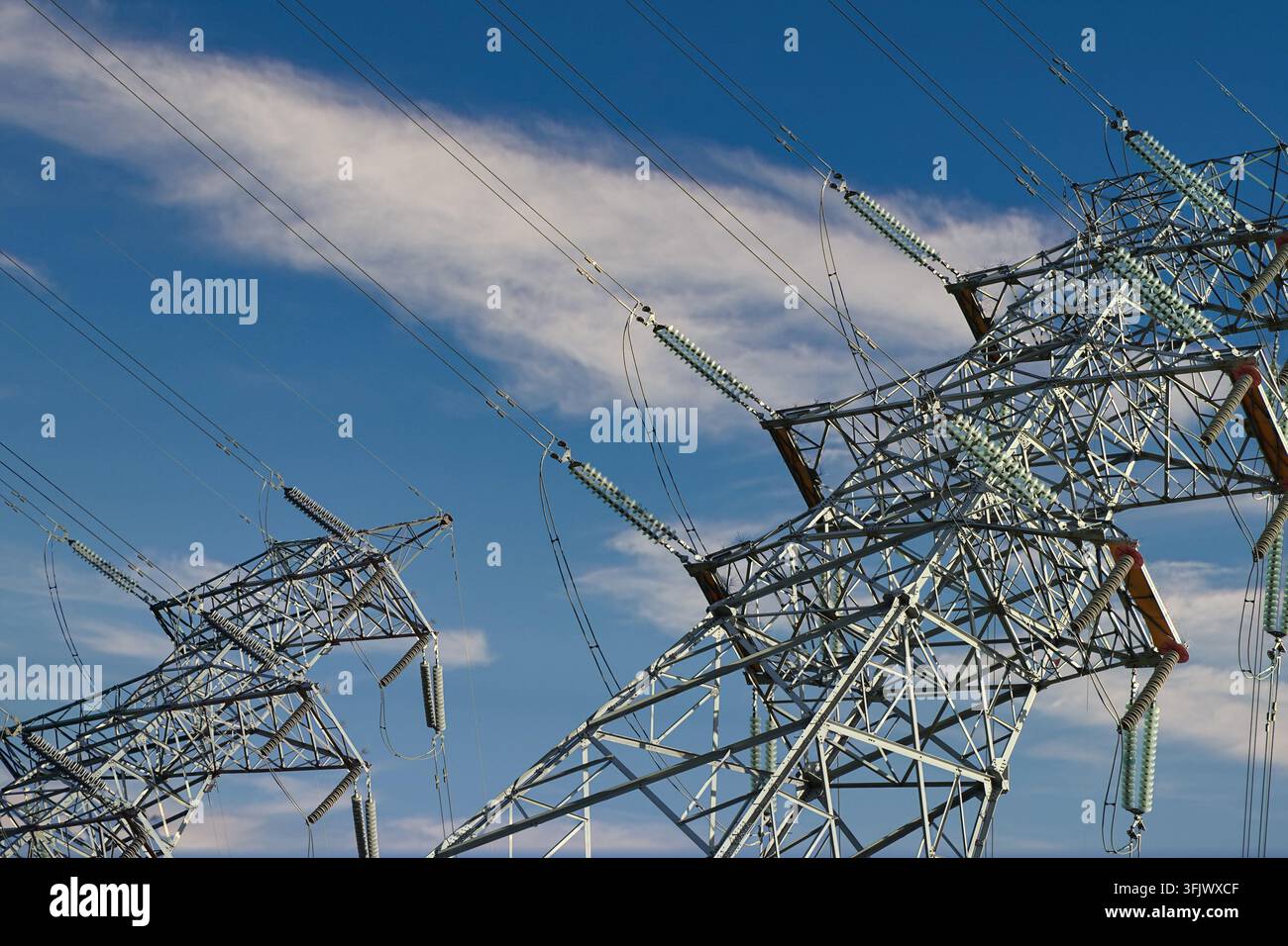 Palo di trasmissione ad alta tensione sotto un cielo blu Foto Stock