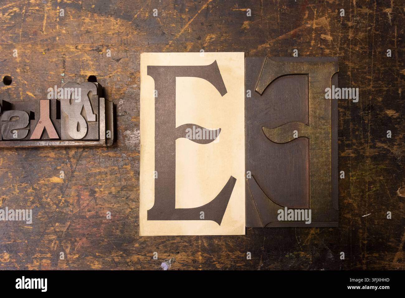 Blocchi di caratteri tipografici e una "E" stampata su un banco da lavoro alla St Bride Foundation di Londra per preservare l’artigianato tipografico tradizionale. Foto Stock