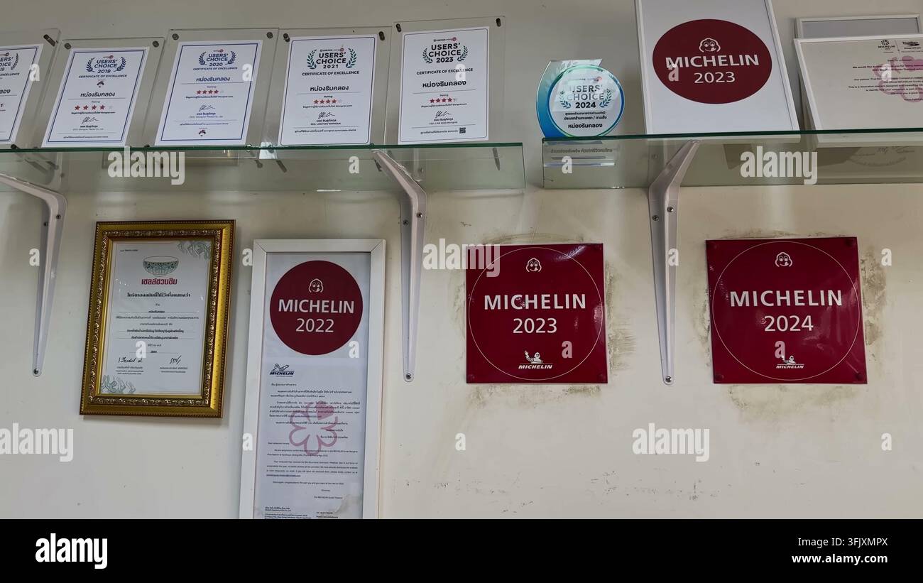 BANGKOK, THAILANDIA - 12 MARZO 2026: Certificati incorniciati Users' Choice e targhe rosse della Guida Michelin del 2022, 2023 e 2024 montati sul muro di No Foto Stock