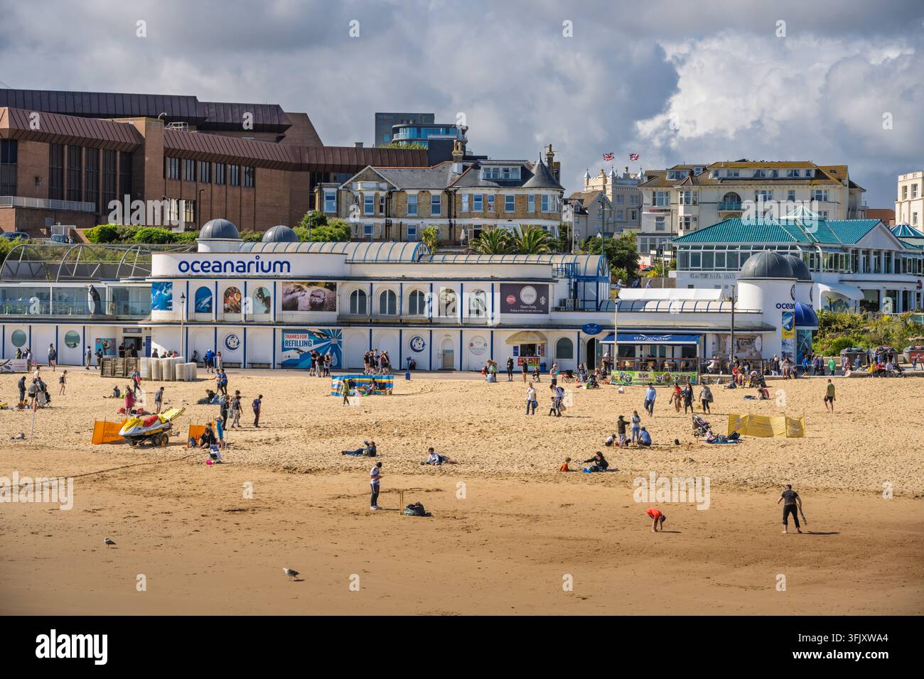 Vista panoramica soleggiata dell'edificio dell'acquario Oceanarium e dei visitatori sulla spiaggia sabbiosa di Bournemouth, Dorset, Inghilterra, Regno Unito Foto Stock