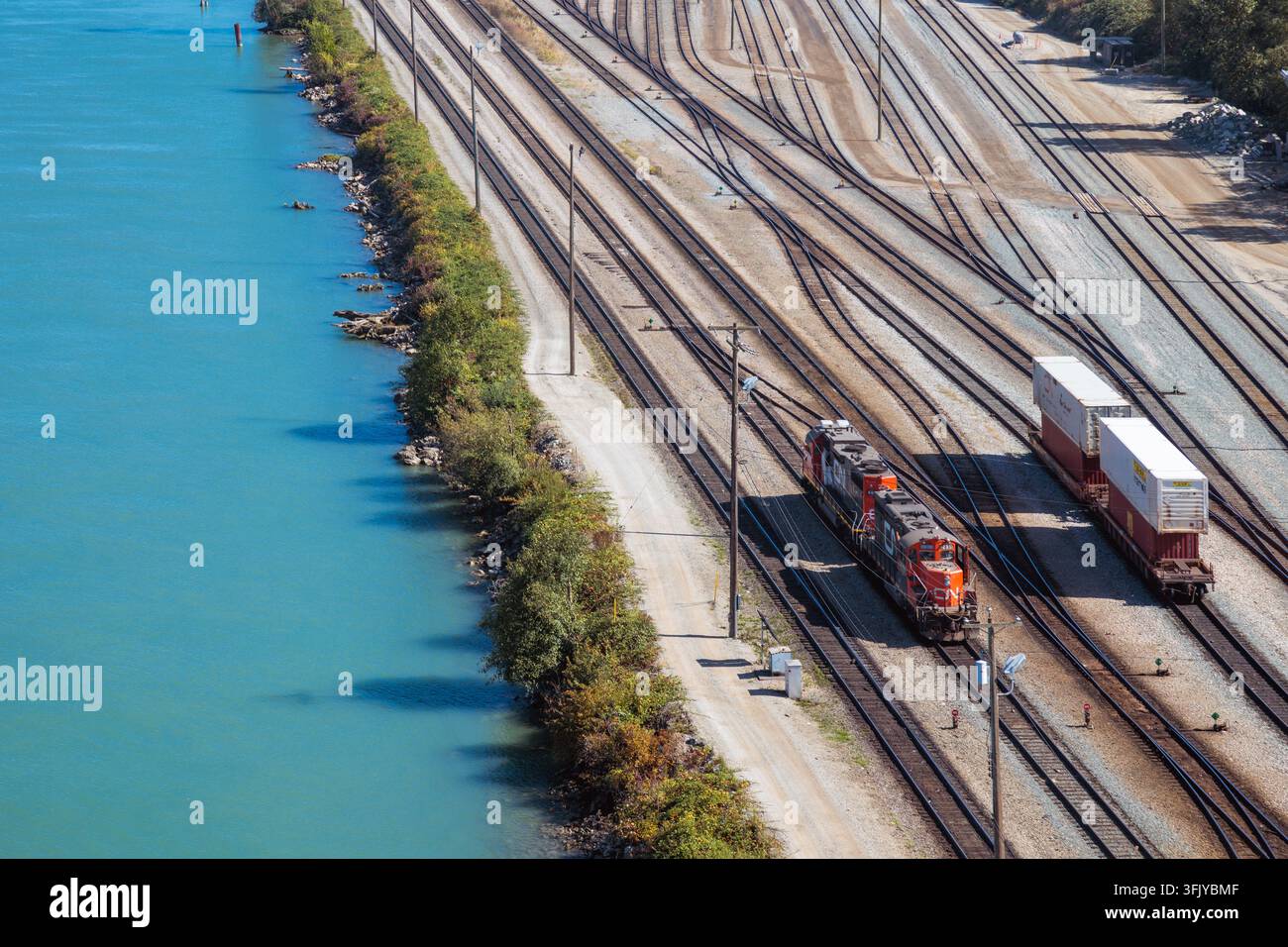 Vista ad angolo alto dei locomotive della Canadian National Rail e dei vagoni container intermodali sui binari dello Thornton Yard presso il fiume Fraser a Surrey BC, Canada. Foto Stock