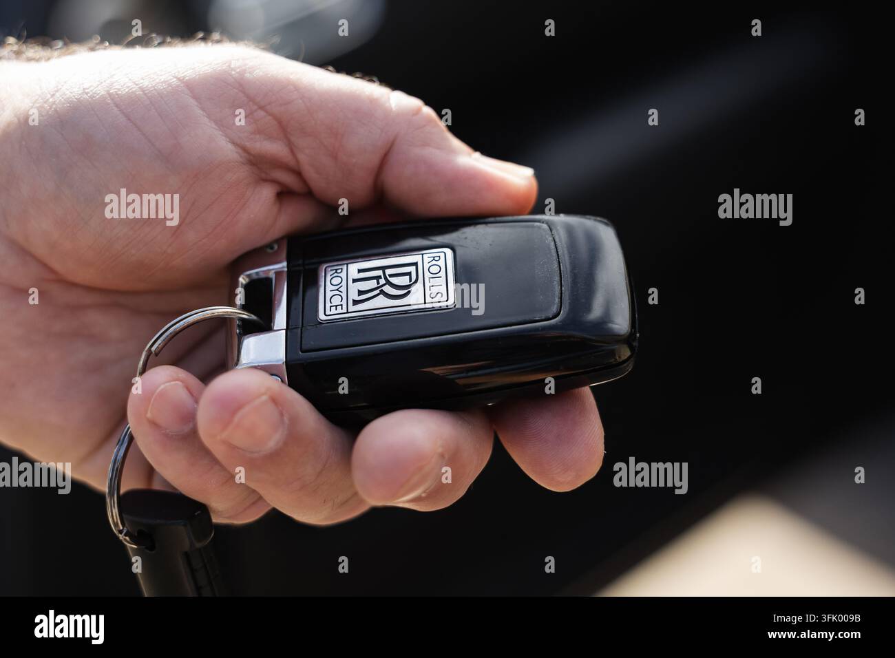 Ljubiana, Slovenia - 14 settembre 2026: Una persona tiene in mano un portachiavi per auto Rolls Royce. L'ambiente è casual e rilassato. Foto Stock