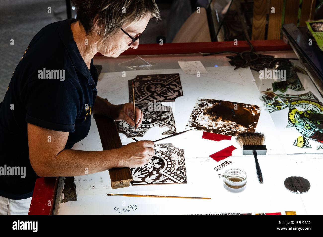 Cécile Boël, Maestra vetraia, al lavoro nella sua officina a Bérulle, nell'Aube (nord-est della Francia), il 24 luglio 2025. Restauro di th Foto Stock