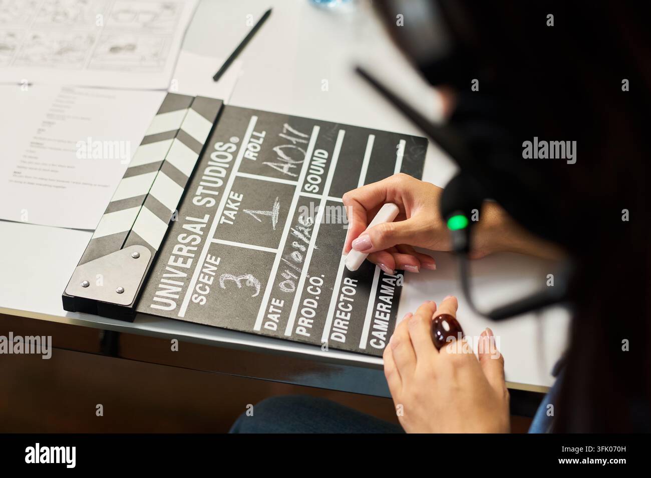 Donna che scrive su una claquetta durante la produzione video Foto Stock