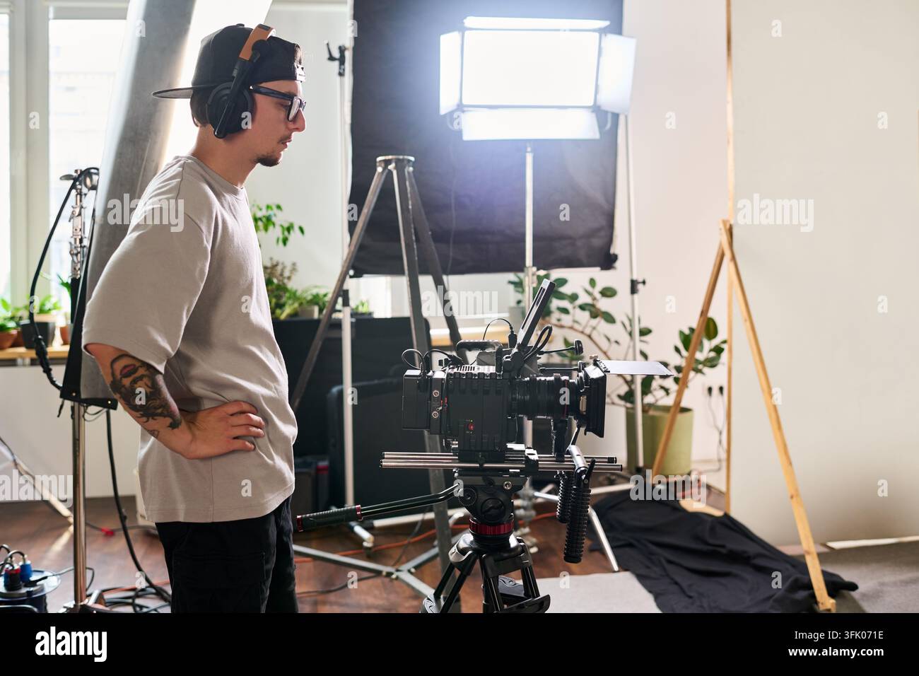 Videomaker che opera una fotocamera cinema professionale in studio Foto Stock